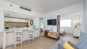 Un apartamento moderno con cocina, sala de estar, televisor y sofá.