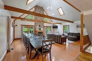A spacious room with a large wooden dining table, a fireplace, a sofa, and a television. - ‘Shady Point Retreat’ w/ Hot Tub & Pickleball! (Killbuck)