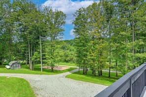 A gravel path leading to a small shed with a door and windows, surrounded by lush green trees and grass. - ‘Shady Point Retreat’ w/ Hot Tub & Pickleball! (Killbuck)