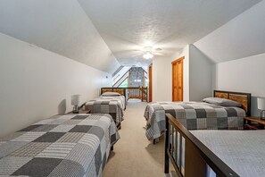 A bedroom with three beds, a ceiling fan, and a staircase leading to an upper level. - ‘Shady Point Retreat’ w/ Hot Tub & Pickleball! (Killbuck)