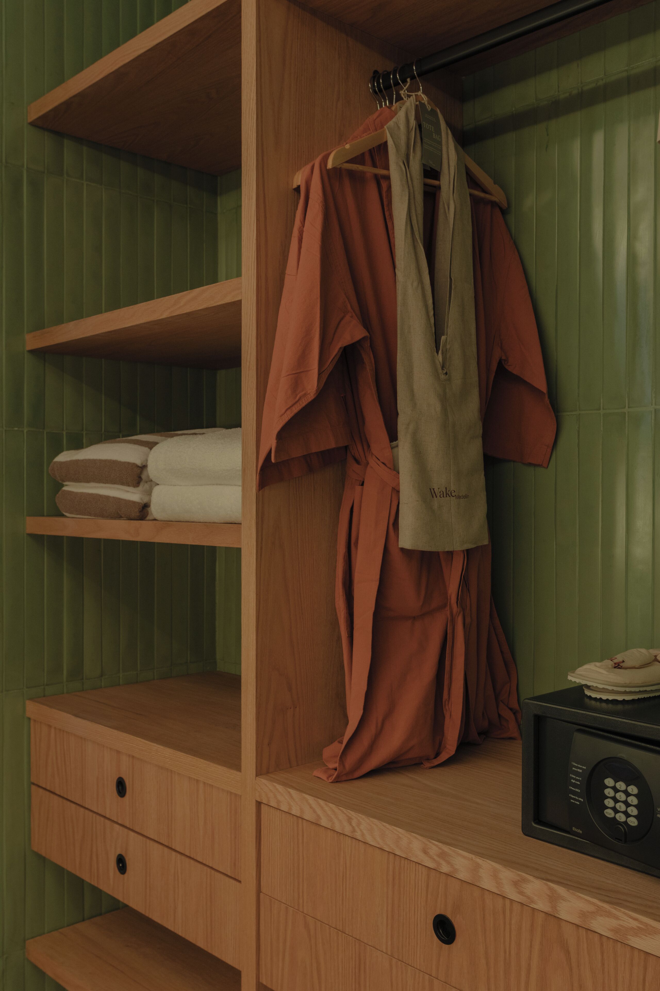A wooden wardrobe with a hanging bag labeled 'Wake-up' and a microwave on the right side.