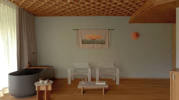 A modern living room with a large bathtub, two white chairs, a small table, and a wooden ceiling.