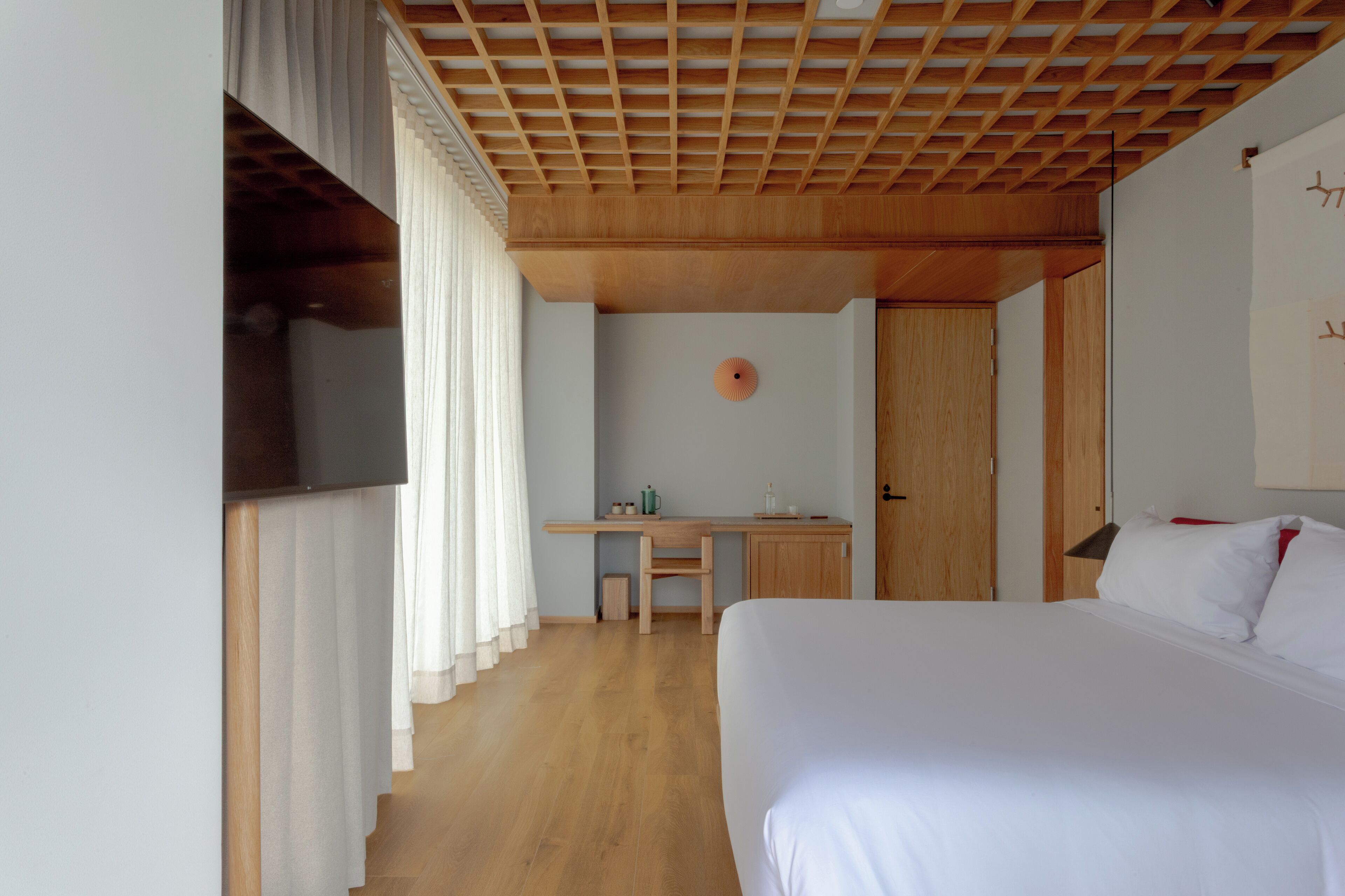 A bedroom with a bed, a desk, and a chair.