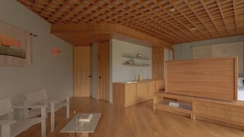 A modern living room with wooden furniture, a large TV, and a wooden ceiling.
