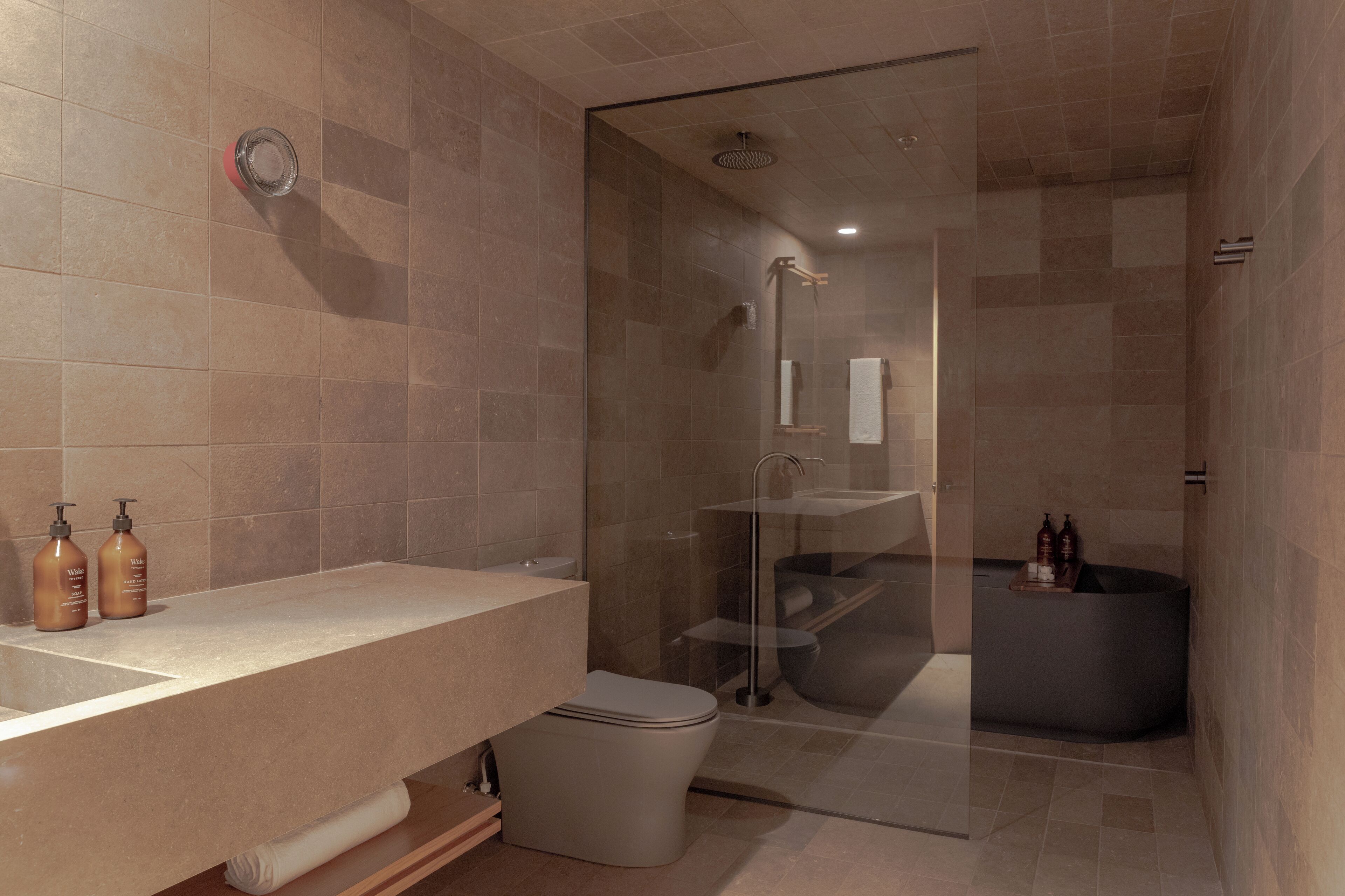 A modern bathroom with a glass-enclosed shower, a vanity with a sink, and a toilet.