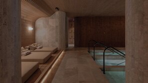 A spa area with a massage table, a small pool, and a staircase. - Wake Medellin, a Member of Design Hotels (Medellín)