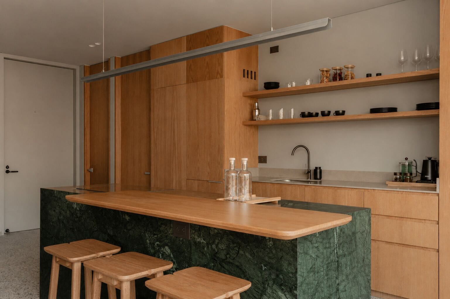 Cozinha moderna com armários de madeira, bancada de mármore e área de bar embutida com banquetas.