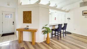 Ein modernes Interieur mit einem Holztisch, zwei Stühlen, einer Wanddekoration und einem Blumentopf.