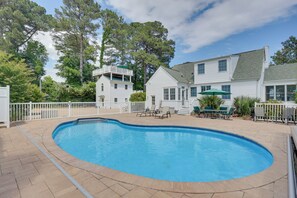 A swimming pool with a white fence, a covered patio area, and a two-story house with a balcony. - Rooftop Chesapeake Bay Views! Waterfront Retreat (Bohannon)