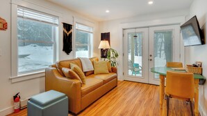 A cozy living room with a leather sofa, a small table, and chairs. There is a window with blinds, a lamp, and a fire extinguisher on the floor. - 6 Mi to Polar Caves! All-Season Getaway w/ Sauna (Plymouth)