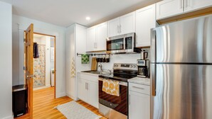 A modern kitchen with white cabinets, stainless steel appliances, and a wooden floor. - 6 Mi to Polar Caves! All-Season Getaway w/ Sauna (Plymouth)