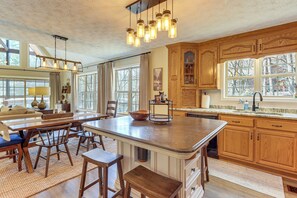 A spacious kitchen with wooden cabinets, a large island, and pendant lighting. - Riverfront, Hot Tub! Coosawattee River Resort Home (Ellijay)