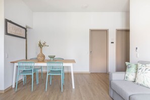 A dining area with a wooden table and two chairs, a vase with flowers, and a framed sign on the wall. - Riva Apt · Lake View - Finestra sul Lago (Navene)