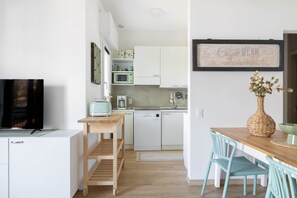 A compact kitchen with white cabinets, a microwave, a toaster, and a sink. - Riva Apt · Lake View - Finestra sul Lago (Navene)