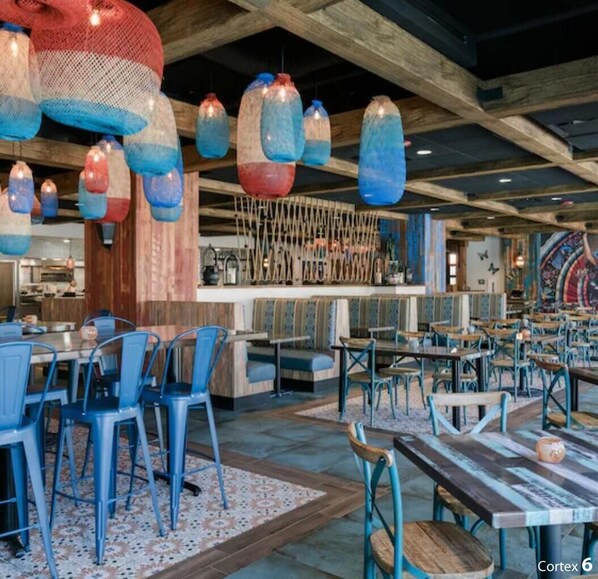 A restaurant interior with wooden beams, blue chairs, and hanging light fixtures. - Westgate Town Center. Resort with 1 bedroom and AC in beautiful Kissimmee (Kissimmee)