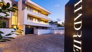A modern multi-story building with a flat roof and a paved courtyard. - Villa Rova – Apartment with a Seaview (Malinska (Krk))