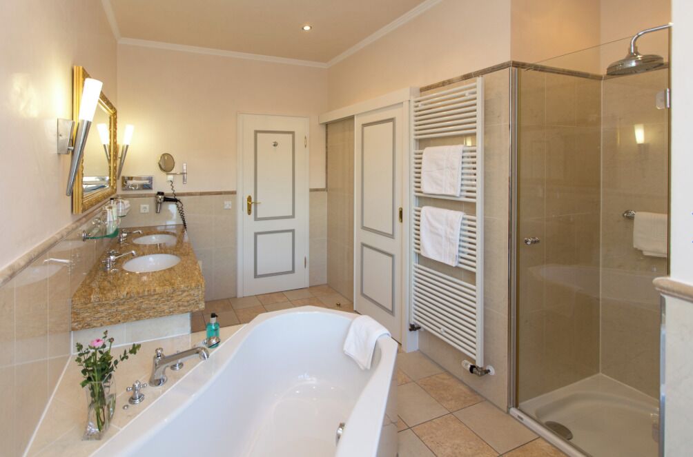 Comfort suite, uitzicht op tuin | Badkamer | Een aparte badkuip en douche, handdoeken, zeep, shampoo