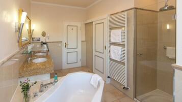 Comfort suite, uitzicht op tuin | Badkamer | Een aparte badkuip en douche, handdoeken, zeep, shampoo