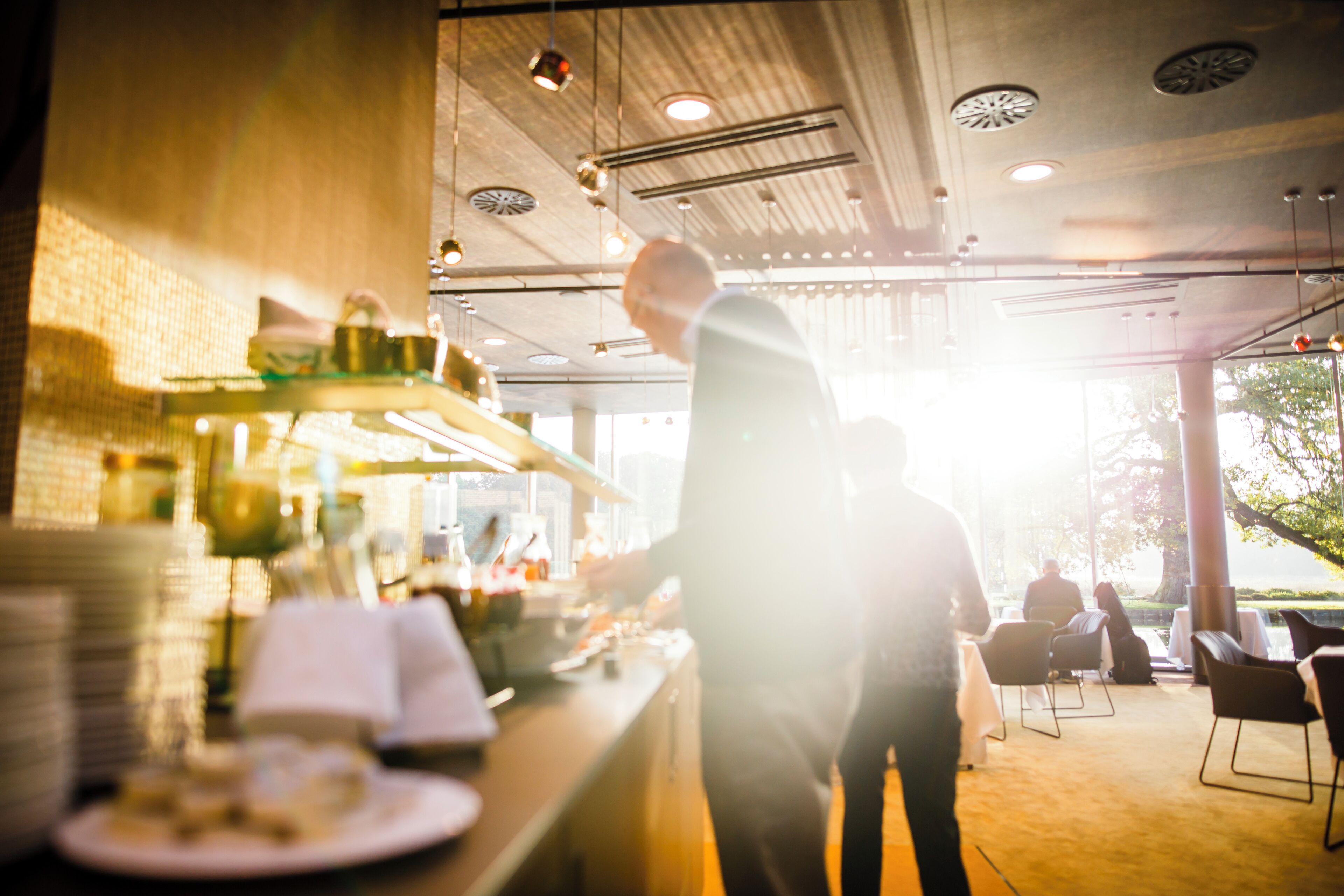 Una zona de bar con mostrador, estantes con productos y vistas al exterior.