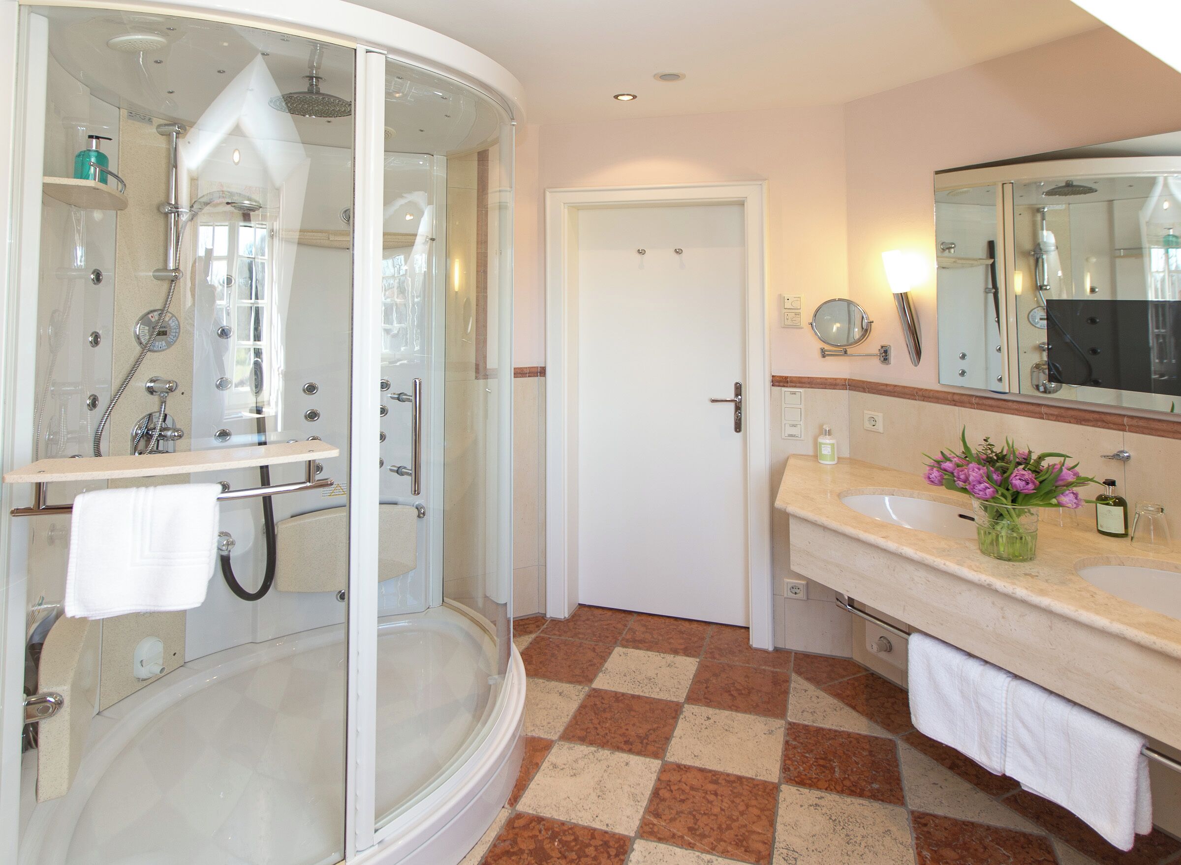 A modern bathroom with a glass-enclosed shower, a separate bathtub, and a vanity with a mirror.