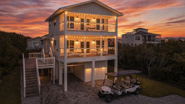Una casa de dos pisos con balcón, terraza y un carrito de golf.