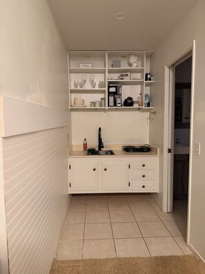 A compact kitchen with white cabinetry, a coffee machine, and a sink. - Cozy 1-bedroom 2 bed studio Lancaster (Lancaster)