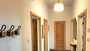A hallway with a coat rack, a wooden door, and a mirror. - Giannotti Vintage Apartment With Two Bedrooms (Firenze)