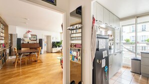Een modern appartement met een eethoek, keuken en uitzicht op de stad.