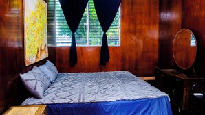 Un dormitorio con cama, cómoda y ventana con cortinas.