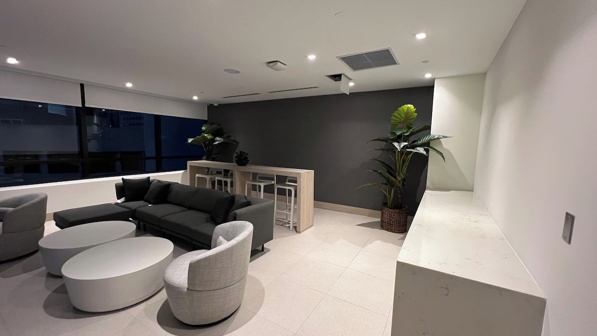A modern living room with a sofa, two round coffee tables, and a side table.