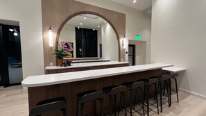 Eine moderne Bar mit einer langen Theke und mehreren Barhocker.