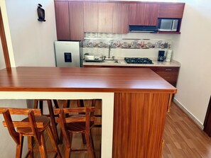 Microondas, cafetera y tetera, utensilios de cocina y comedor 