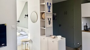 Et moderne soveværelse med seng, natbord og et garderobeskab med hylder.