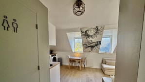 En kompakt bolig med et tekøkken, spiseplads og en sofa.