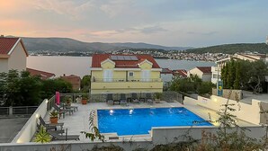 Un espace piscine aménagé sur le toit, offrant une vue sur un lac et des collines lointaines.