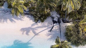 An aerial view of a beach with clear turquoise water, white sand, and palm trees. - Handhuvaru Maldives (Milandhoo)
