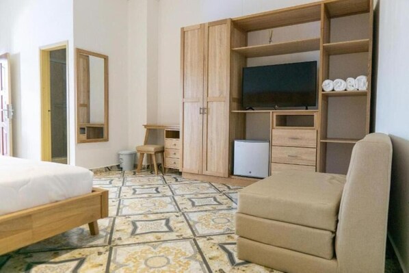 A bedroom with a bed, a chair, a TV, a wardrobe, and a desk. - Hotel Abitti (Taganga)