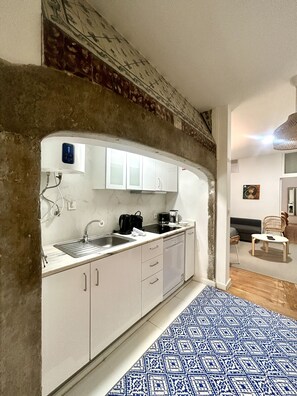 A compact kitchen with white cabinets, a built-in oven, and a coffee maker. - SJ2E Spacious & Comfortable | DT | A/C (Lisboa ciudad)