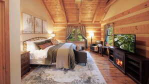 Un dormitorio con cama, televisión, chimenea y ventilador de techo.