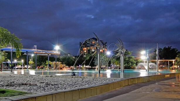 A nighttime view of a beach area with a pool, a large metal sculpture, and a building in the background. - Family Entertainer in Kanimbla - Space & Privacy (Kanimbla)
