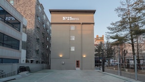 En hotellbyggnad med en skylt som visar texten ”Hotell nummer 25” och en entré med grind.