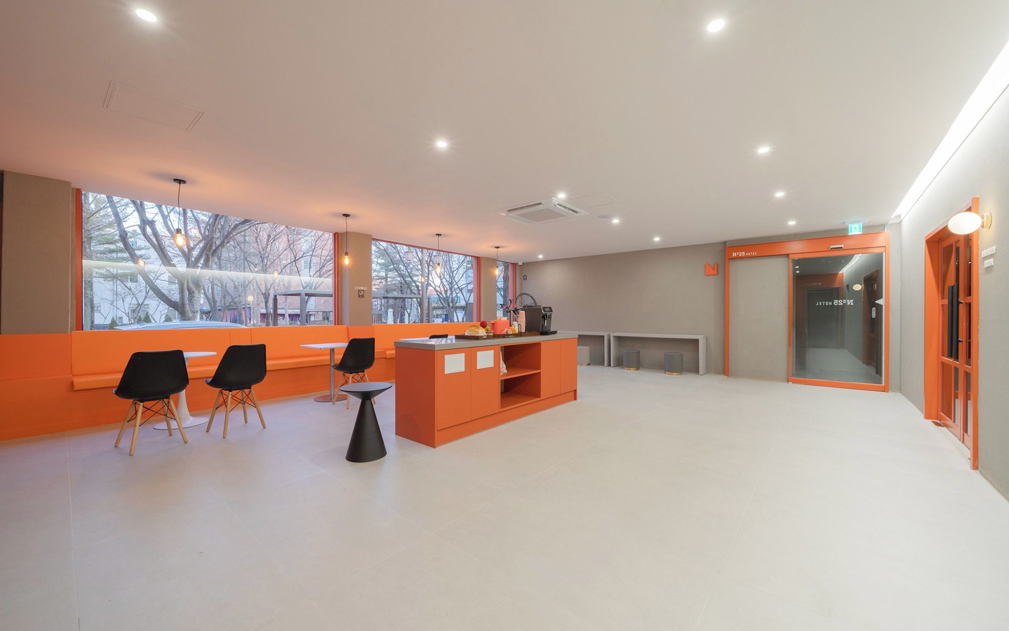 Vestíbulo de hotel con mostrador de recepción, zona de estar y ventanas amplias.