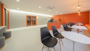 A modern interior with a reception desk, seating area, and a staircase.