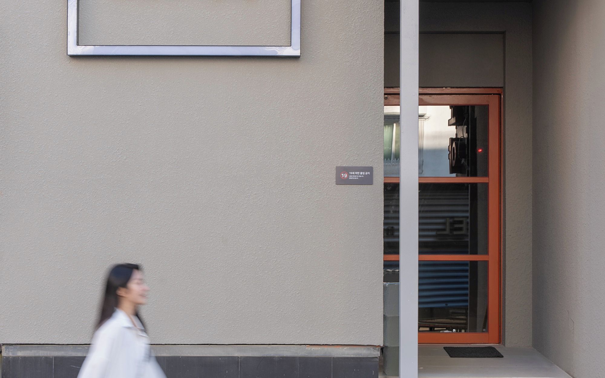 A building entrance with a door and a sign indicating the number 19.