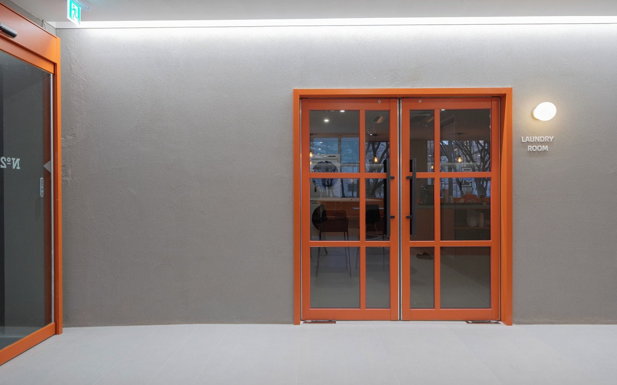 A building entrance with a glass door and a sign indicating a laundry room.