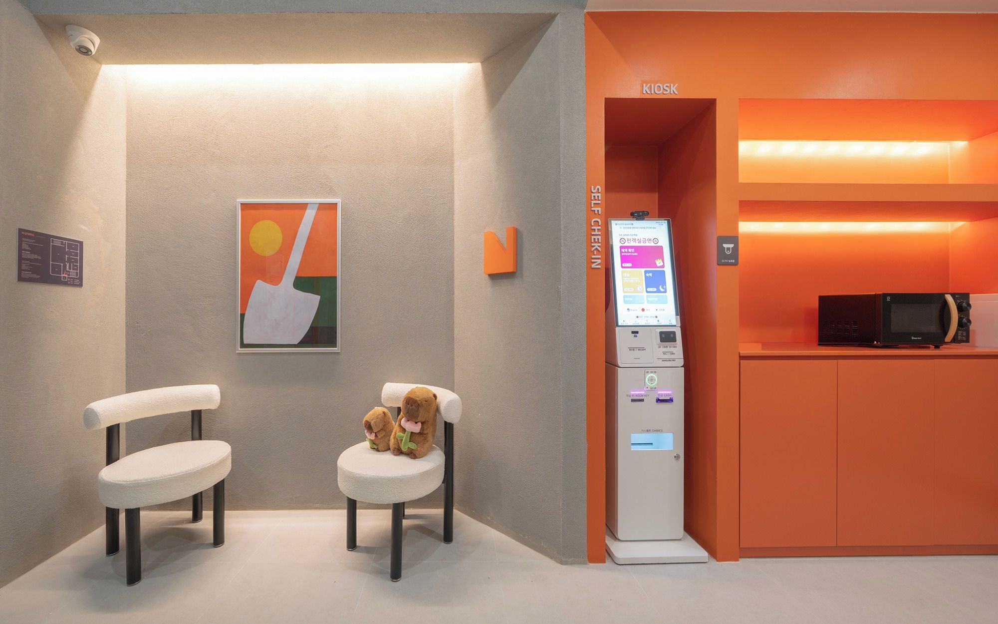 A kiosk with a digital screen, a microwave, and a sign indicating a self-check-in area.