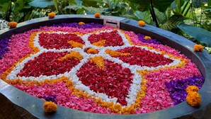 Un arreglo floral circular con diseño de corazón, rodeado de follaje.