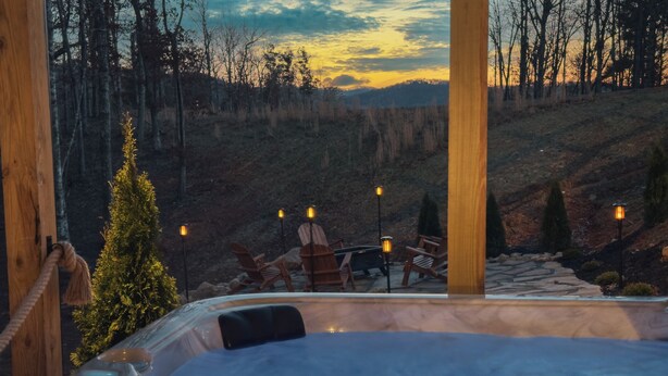 A hot tub with a view of a forested hillside at sunset. - Hideout in Blue Ridge (Morganton)