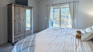 A bedroom with a bed, a ceiling fan, a wardrobe, and a window with curtains. - Hideout in Blue Ridge (Morganton)