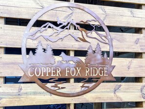 A metal sign with a forest scene and the text "Copper Fox Ridge". - Copper Fox Ridge | Minutes to Carter's Lake | Game Room + Hot Tub + Screened Deck (Ellijay)